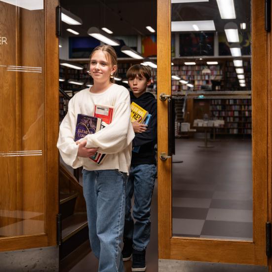 Børn på vej ud af biblioteket med bøger