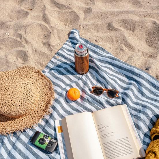 Tæppe og bog på strand